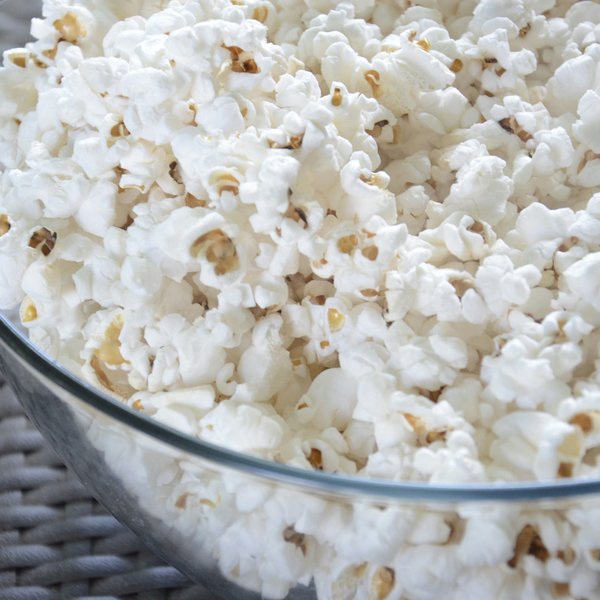 A glass bowl filled with popcorn.