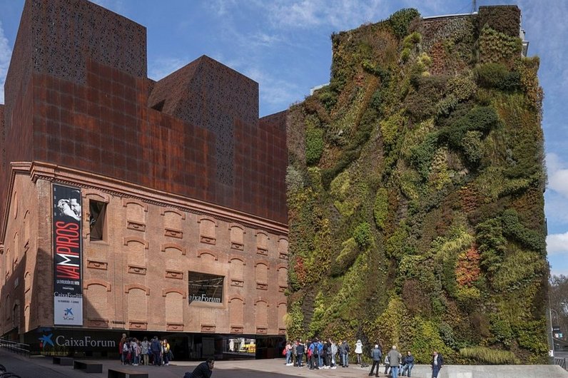 The Caixa Forum building in Barcelona with an impressive vertical garden wall lushly covered with various plants.