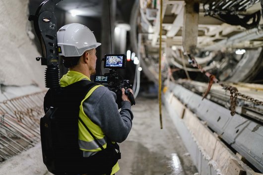 Mann mit Kamera filmt Tunnelvortriebsmaschine