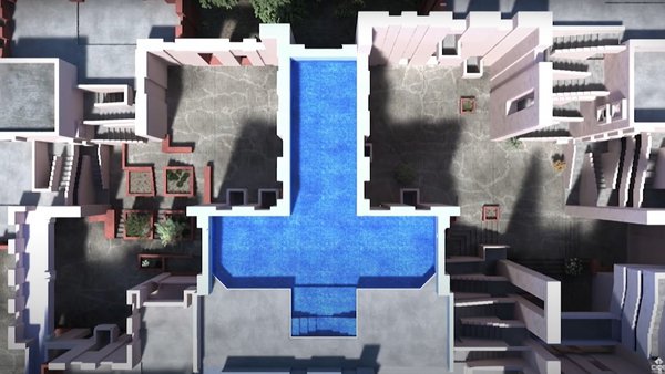 Drone shot of a cross-shaped pool, surrounded by courtyards and stairs