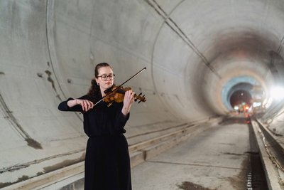 Frau mit Geige in einem Tunnel