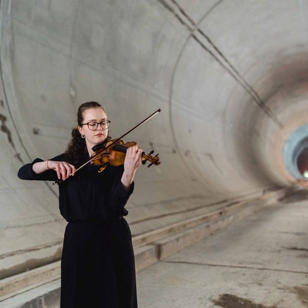 Frau mit Geige in einem Tunnel