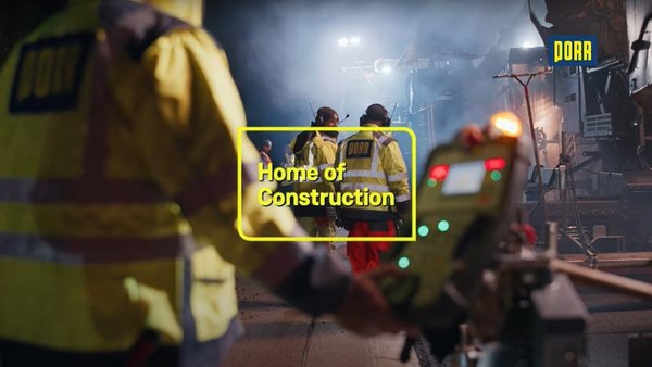 Screenshot aus einem Video zeigt Bauarbeiter der PORR nachts auf einer Straßenbaustelle, mittig steht Home of Construction
