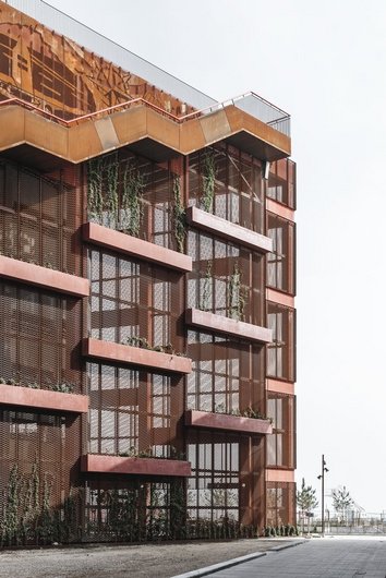 Modern building with rust-coloured metal grid and vertical gardens.