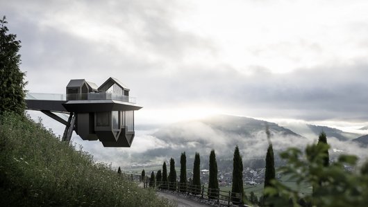 A modern house on a steep slope that partly towers over the abyss.