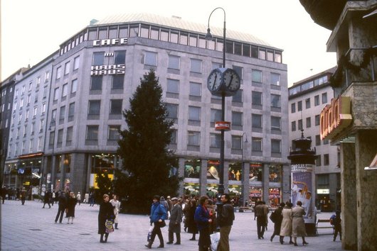 Post-war building in the background, in front of it a square with people