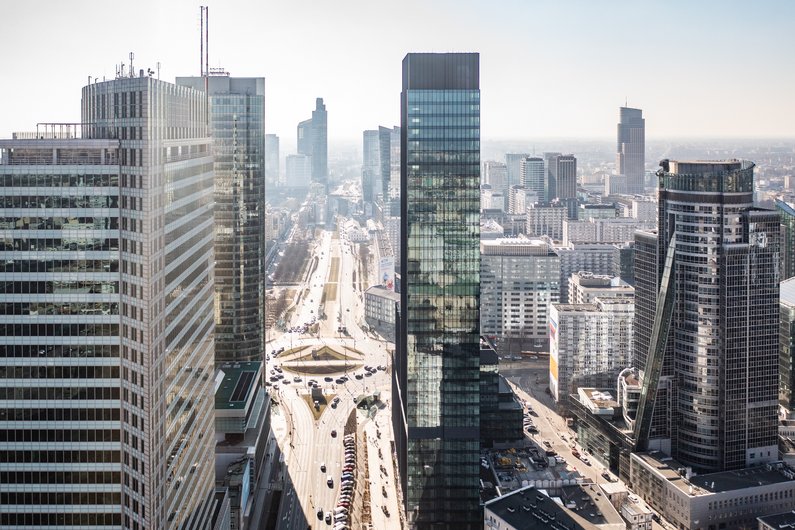 An urban landscape with modern skyscrapers and wide streets under a clear sky.