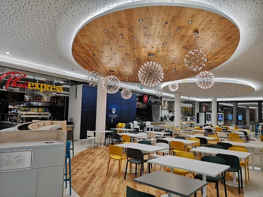 A modern food court with various food stalls.