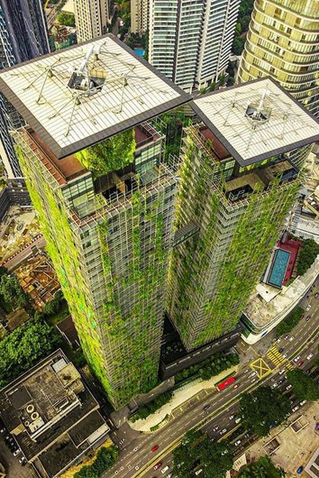 A tall building whose façade is completely covered with plants.