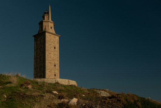 antique, brown lighthouse on a hill