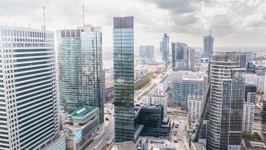 An urban landscape with modern skyscrapers and wide streets under a clear sky.