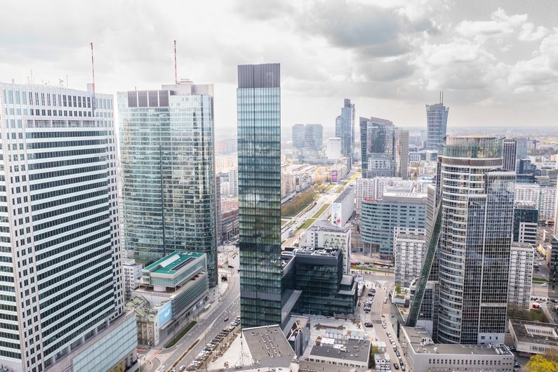 An urban landscape with modern skyscrapers and wide streets under a clear sky.